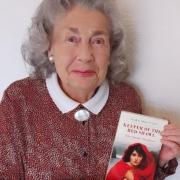 Marie Sarginson holding a copy of ‘Keeper of the Red Shawl: The Secret Shadows’.