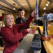 Helen Morgan MP, with bar manager Michael McAllister, pours the first pint.