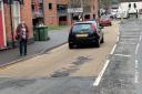 COMPLAINT: Lynn Denham near the pothole in George Street outside St Martin's Gate car park in Worcester