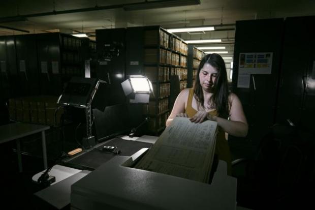 Whitchurch Herald: Photo via PA shows Findmypast technician Laura Gowing scans individual pages of the 30,000 volumes of the 1921 Census at the Office for National Statistics (ONS) near Southampton.