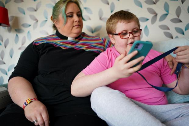 Whitchurch Herald: EMBARGOED TO 0001 WEDNESDAY MARCH 30 Rev Charlotte Cheshire with her son Adam Cheshire at their home in Newport, Shropshire. Adam was left with severe disabilities after staff failed to administer antibiotics for seven hours when he caught an infection