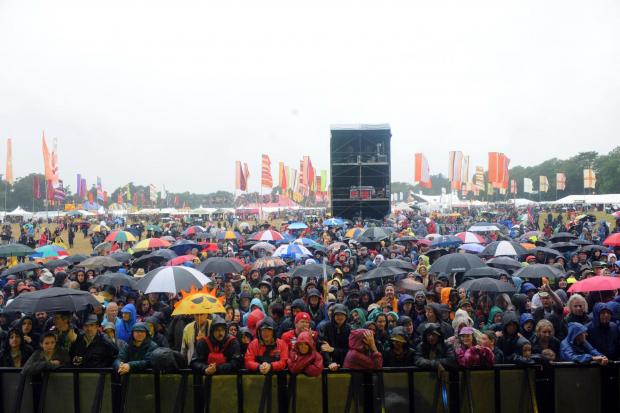 Whitchurch Herald: Festival crowds in the rain. Credit: PA