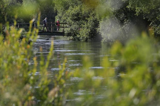 EMBARGOED TO 0001 THURSDAY MAY 12 File photo dated 24/06/20 of people walking across a bridge over the river Itchen near to Ovington in Hampshire. Toxic air that harms health, and water pollution from sewage and farming must be tackled as urgent