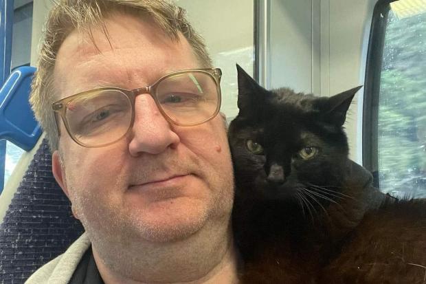 The rescue cat sits on Mr Fenn's shoulders and stops him from feeling “overwhelmed” and “anxious” (PA)