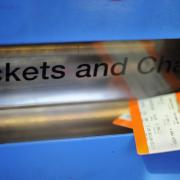 Tickets being bought from a machine at a railway station.