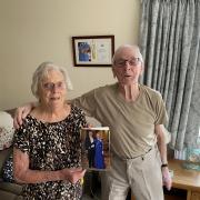 Pearl and Stan Biddulph with their cards from Queen Elizabeth II and King Charles III at their home.
