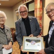 Whitchurch Rotary president Graham King (centre) presents the club’s tribute to Roly Wyatt and his wife, Kath.