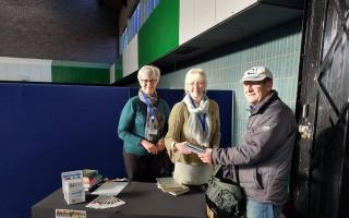 Whitchurch Library staff with a reader returning books on the market stall, on a recent Friday.